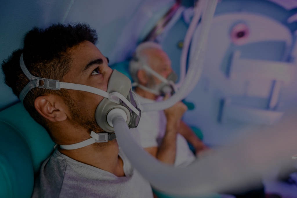 Diverse patients receiving treatment in a hyperbaric chamber.